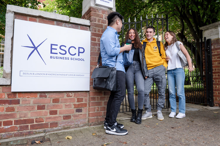 4 Bachelor students talking and laughing in front of the courtyard gate of the London campus of ESCP Business School