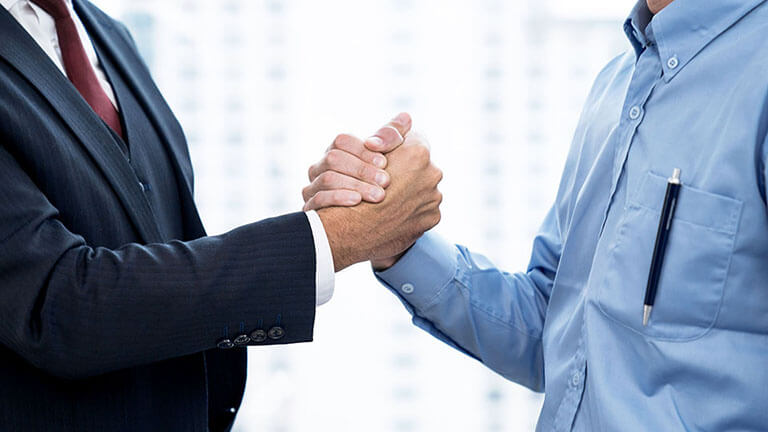 Business people shake hands when reaching a business agreement together, © Basicdog / Shutterstock
