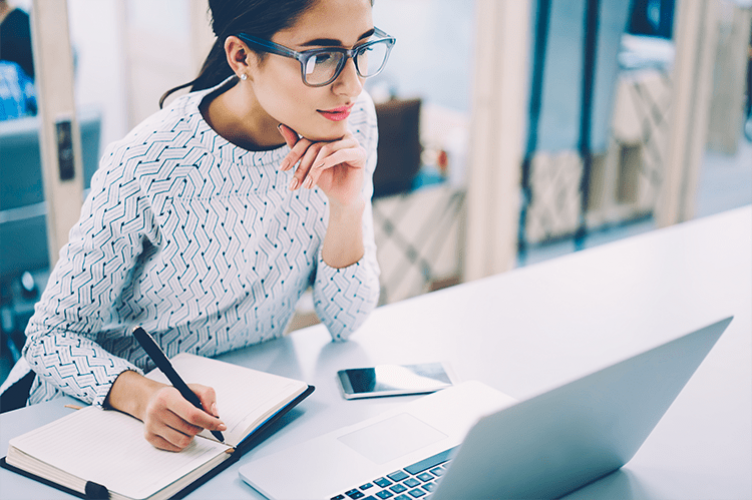 Women sitting at a table looking at her laptop