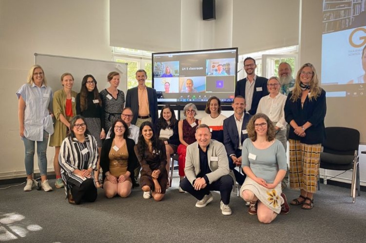 Group of educators standing around a Zoom screen during the ESCP-UNEP Symposium