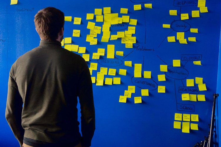 © Per Lööv - Unsplash [copyright] , Man in grey long-sleeved shirt standing in front of a blue and yellow puzzle mat 