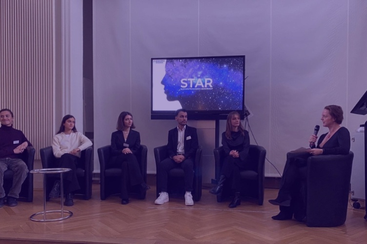 A panel of speakers sitting on a stage