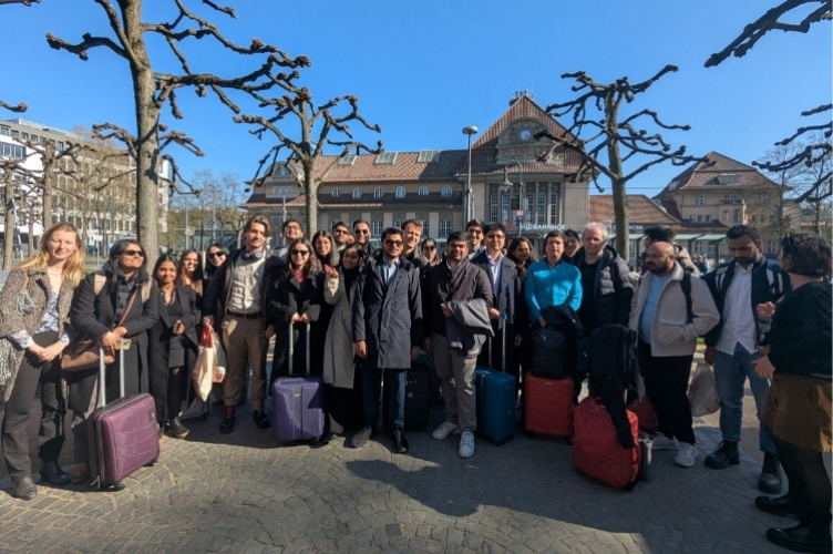 A group of MBA students standing with their luggage outside the Frankfurt train station