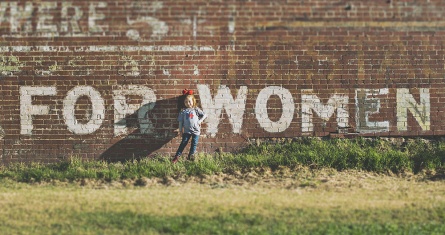 Girl standing near brown building during daytime