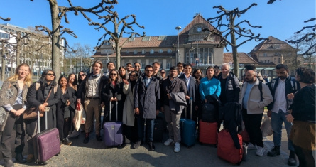 A group of MBA students standing with their luggage outside the Frankfurt train station