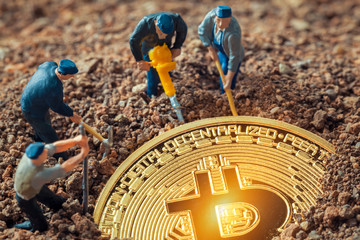 Macro miner figurines digging ground to uncover big shiny bitcoin
