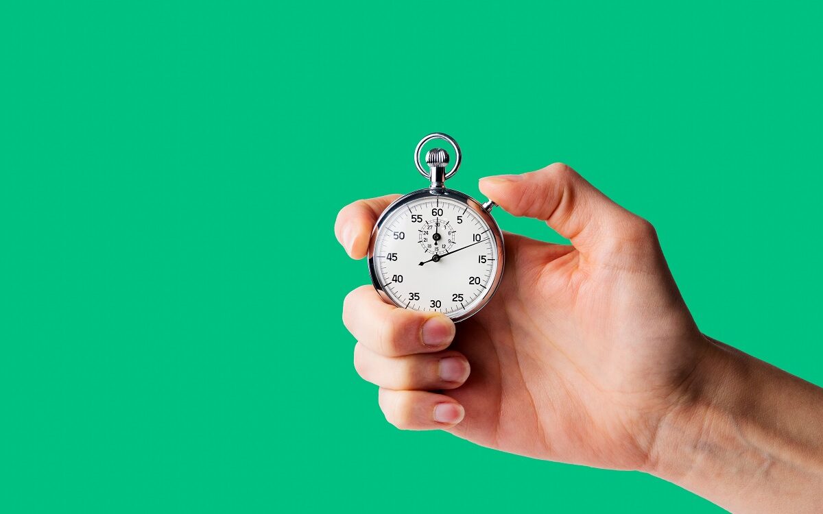 ©Alextype / Adobe Stock A hand holds a stopwatch in front of a bright green background