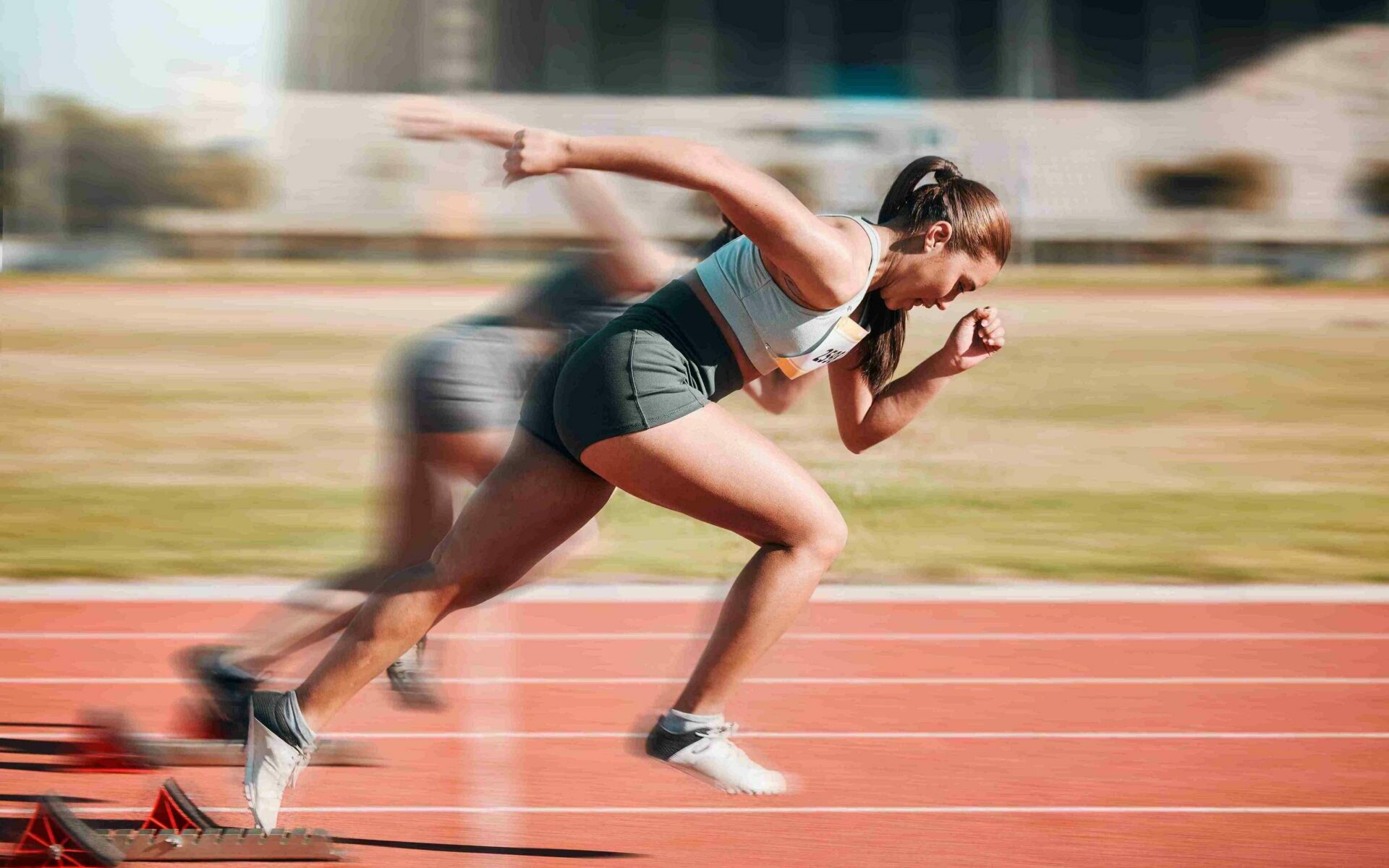 © Mumtaaz D / Adobe Stock A woman running on a track going fast enough that her legs are blurry.