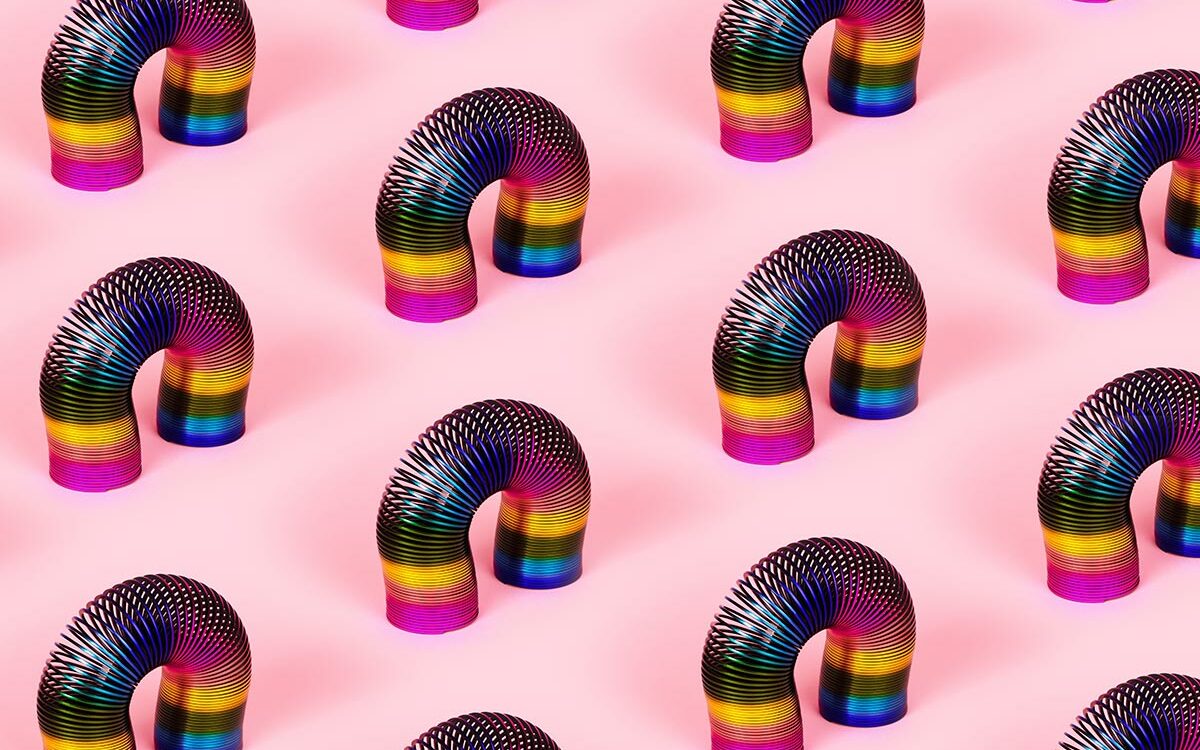 alesmunt-AdobeStock colorful retro toys, slinky pattern over pink background