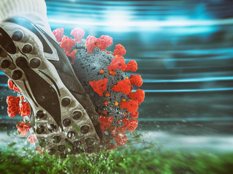 Soccer player kicking hard the virus ball at the stadium