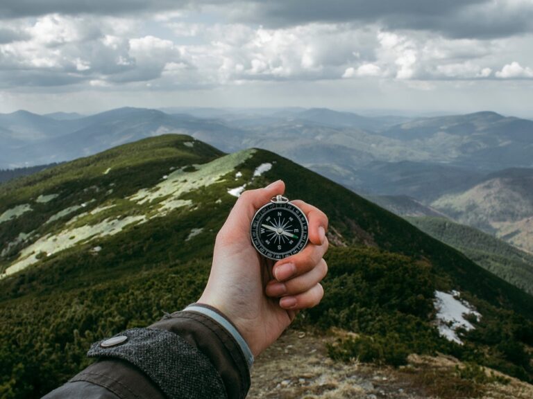 Man holding a compass on a mountain