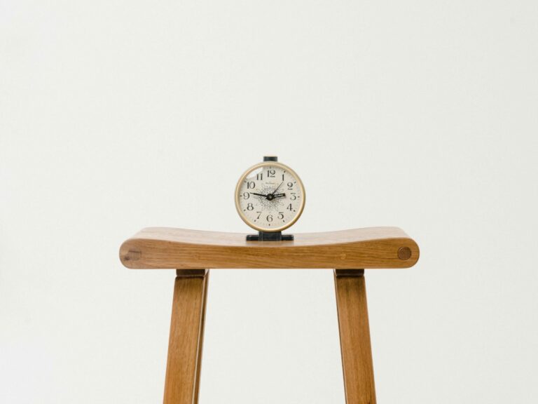 An alarm clock sitting on a stool
