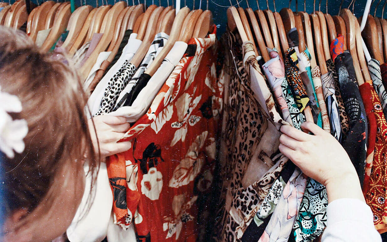 © Becca McHaffie / Unsplash Person holding assorted clothes in wooden hanger, © Becca McHaffie / Unsplash