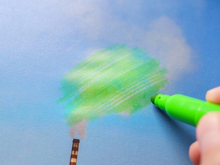 Picture of someone drawing green smoke coming out of a factory chimney