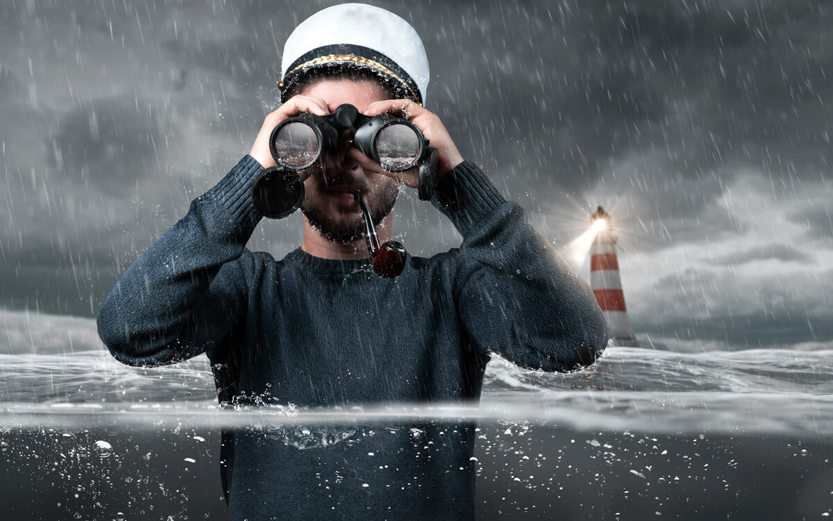Brilliant Eye – AdobeStock Shipwrecked captain standing underwater and watching with binoculars
