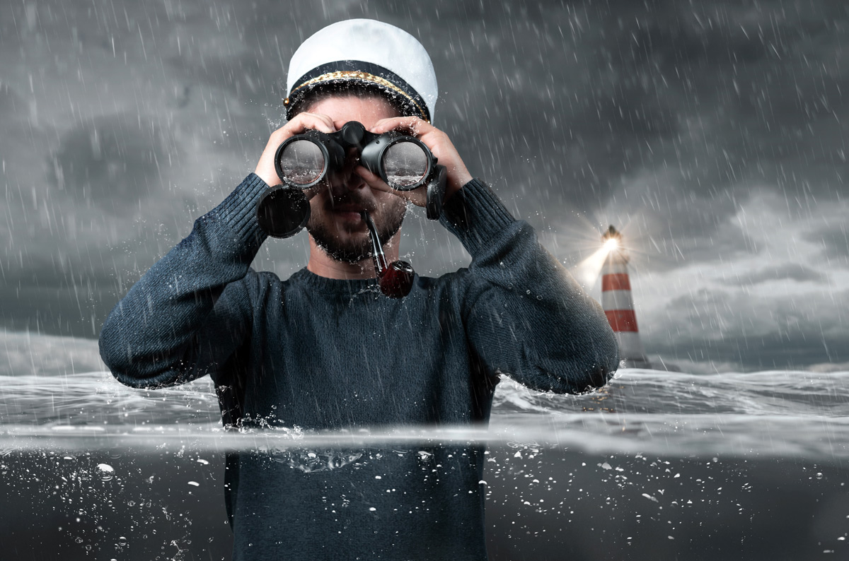 Shipwrecked captain standing underwater and watching with binoculars