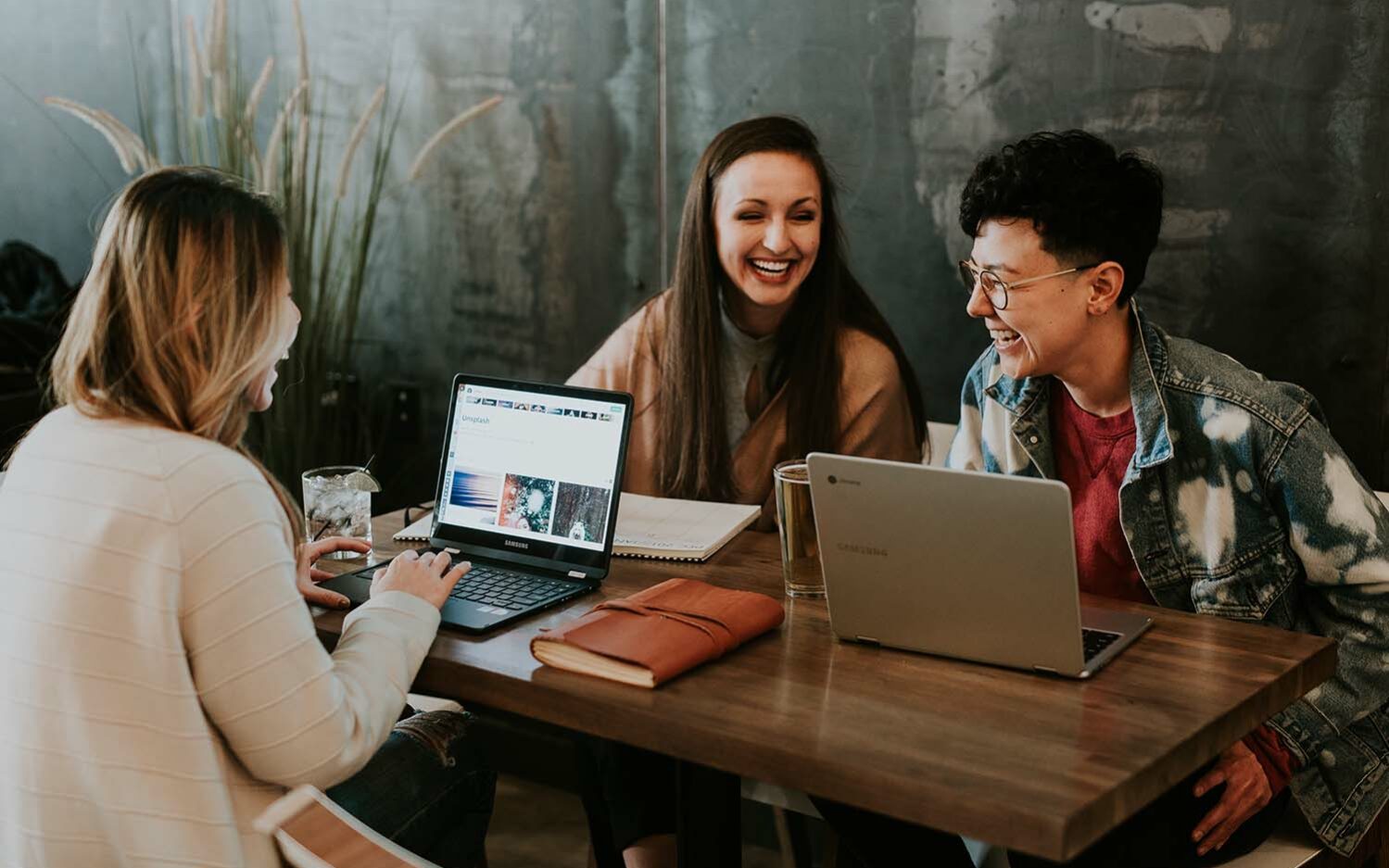 Feature photo by Brooke Cagle/Unsplash Picture of three young women sitting around a table, talking and laughing.