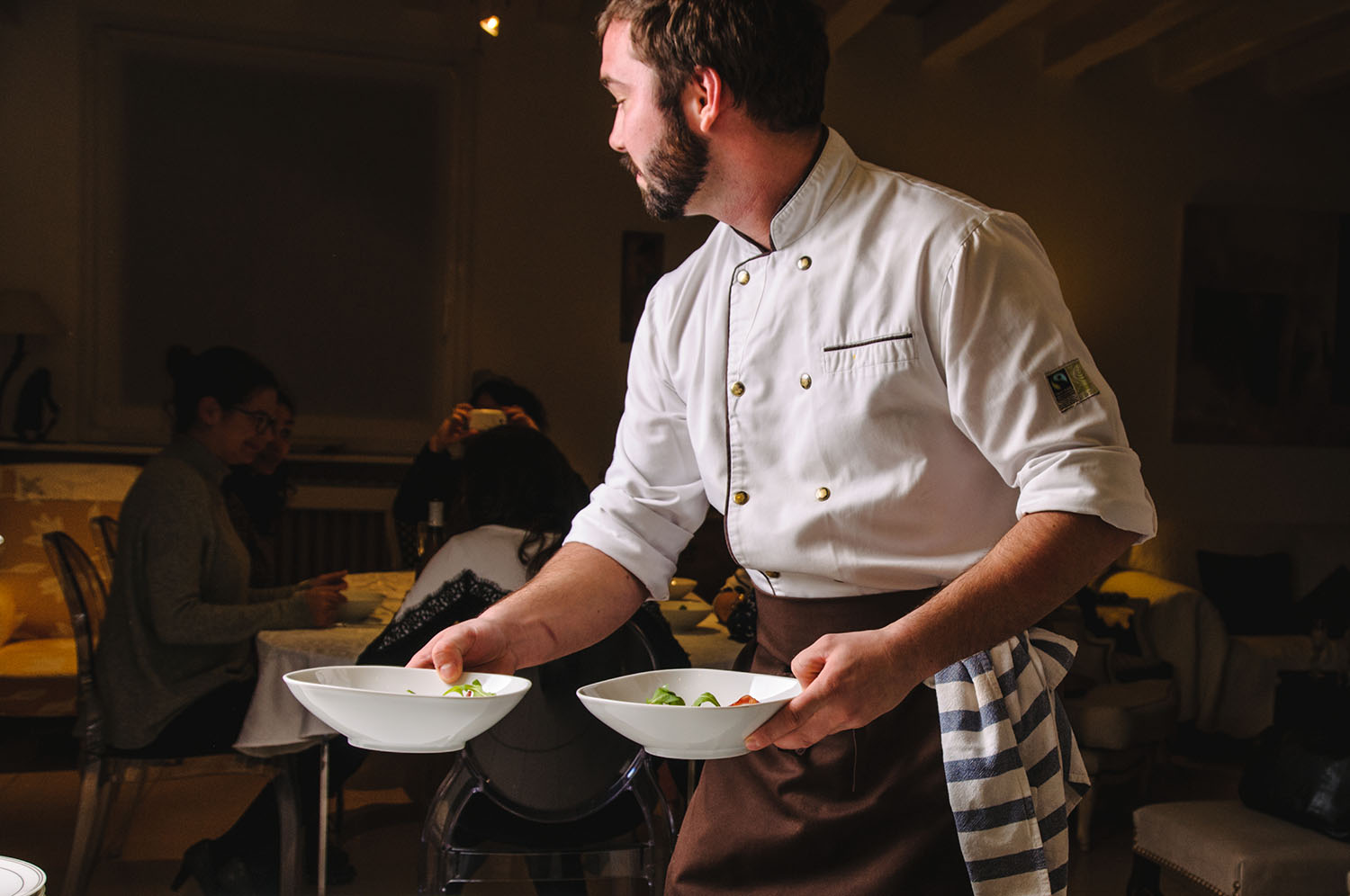 Professional chef serving dishes in a guest's home. © La Belle Assiette