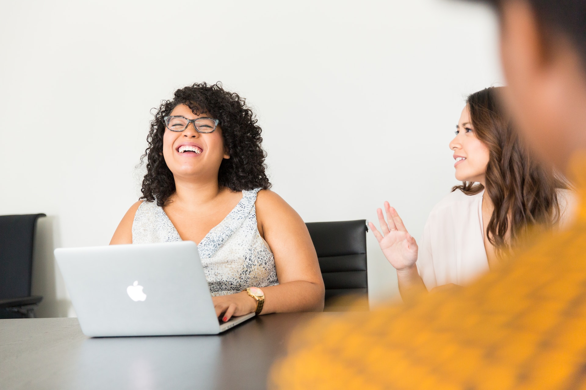 Photo of a woman laughing with her colleagues during a meeting