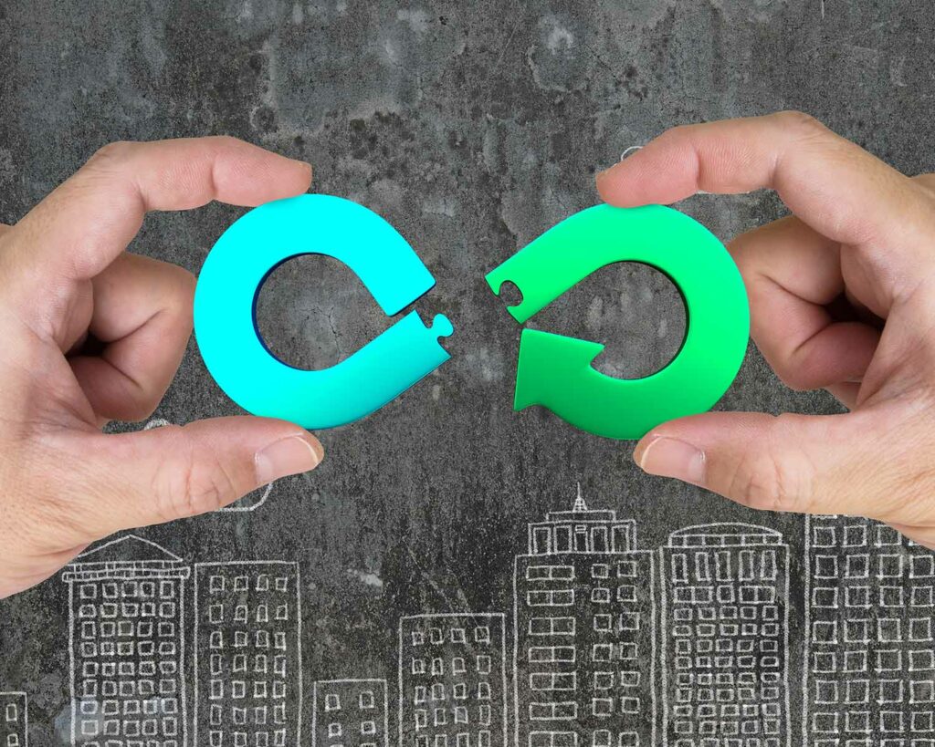 Circular economy concept. Two hands assembling arrow infinity recycling symbol of jigsaw puzzle pieces, on city buildings doodles background.
