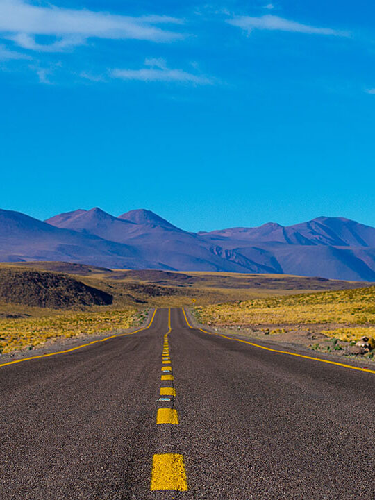 ©Daniel Cartin / Unsplash Empty paved road near mountains during daytime, ©Daniel Cartin / Unsplash