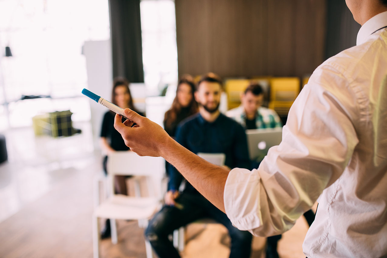 Lecture and training in business office for white collar colleagues. Focus on hands of speaker. ©F8studio / Adobe Stock