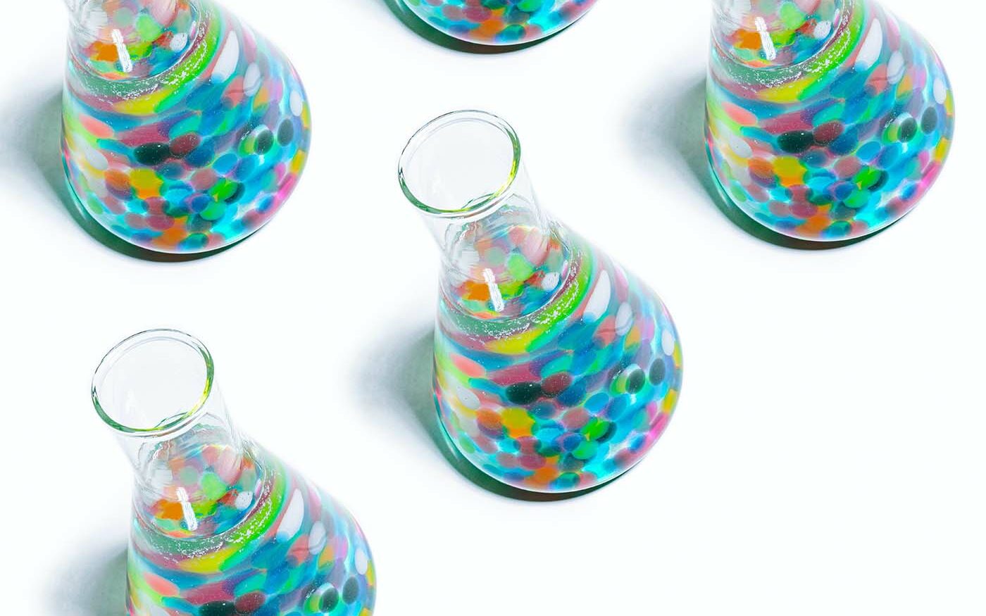 ©Girl with Red Hat/Unsplash Photo of Erlenmeyer flasks filled with colorful items