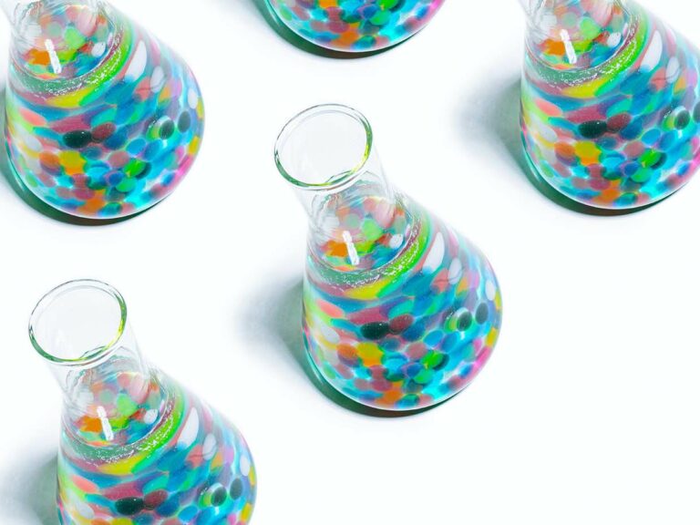 Photo of Erlenmeyer flasks filled with colorful items