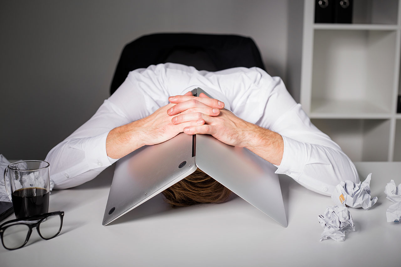 Man hiding under laptop, © Getty / Grinvalds