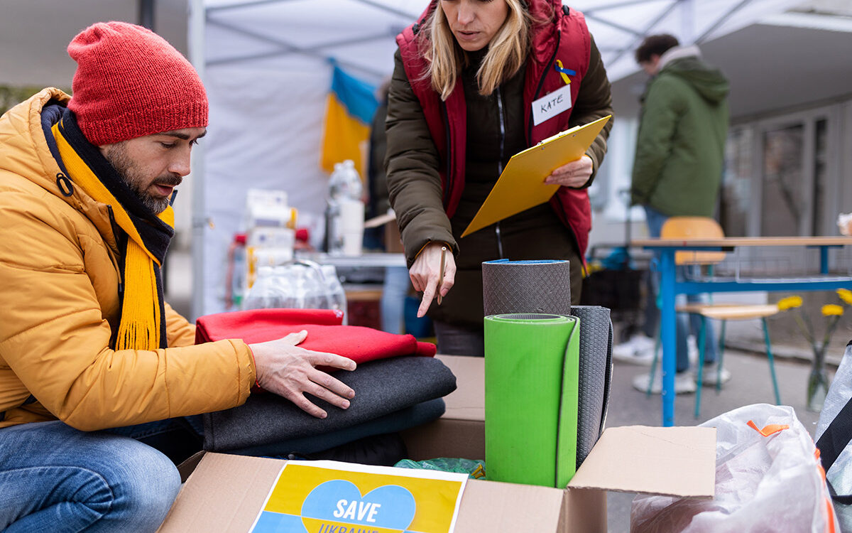 Halfpoint-AdobeStock Volunteers distributing blankets and other donations to refugees on the Ukrainian border.
