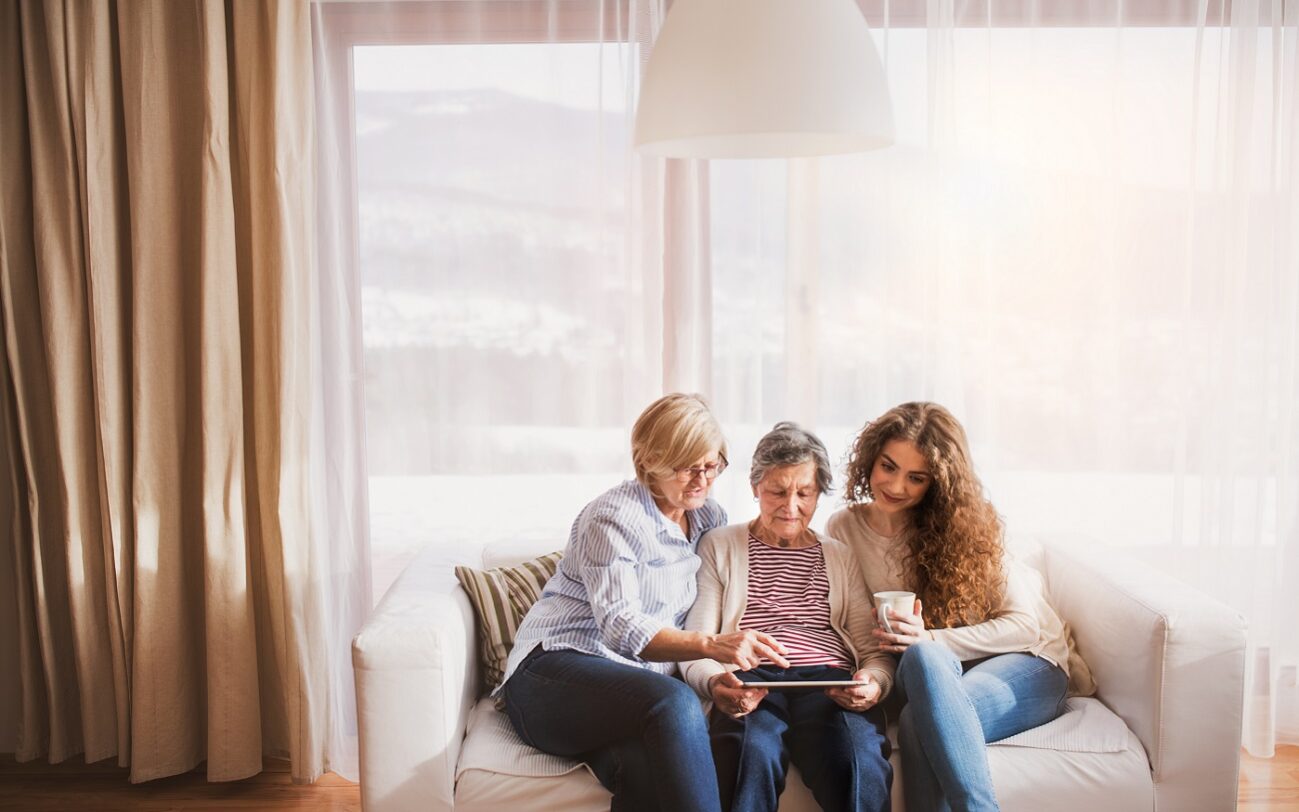 Halfpoint/AdobeStock A teenage girl and mother teaching the grandmother how to use a tablet.
