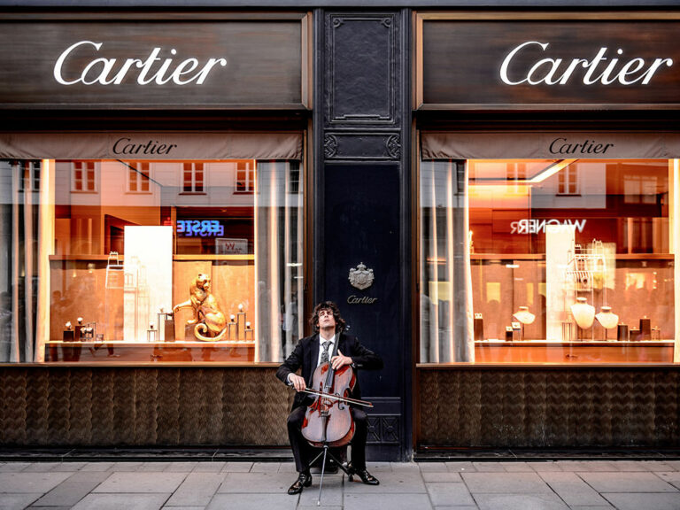 Man playing cello in front of store © Jacek Dylag / Unsplash
