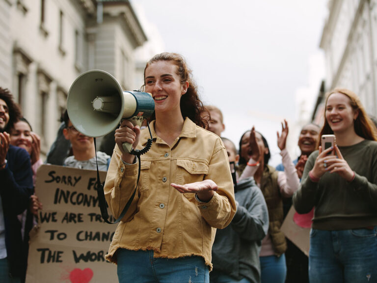 Woman with a megaphone in a rally, © Jacob Lund / Adobe stock