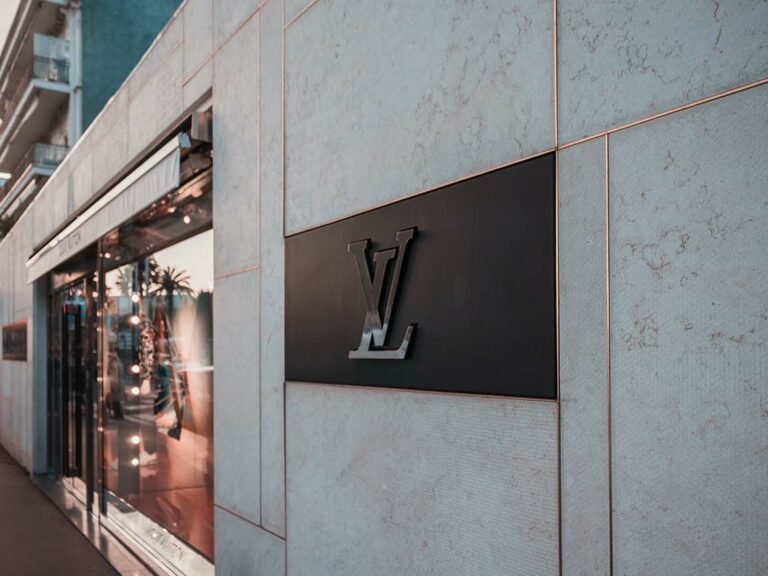 Feature photo by Jannis Lucas/Unsplash. Photo of Louis Vuitton logo outside a store.