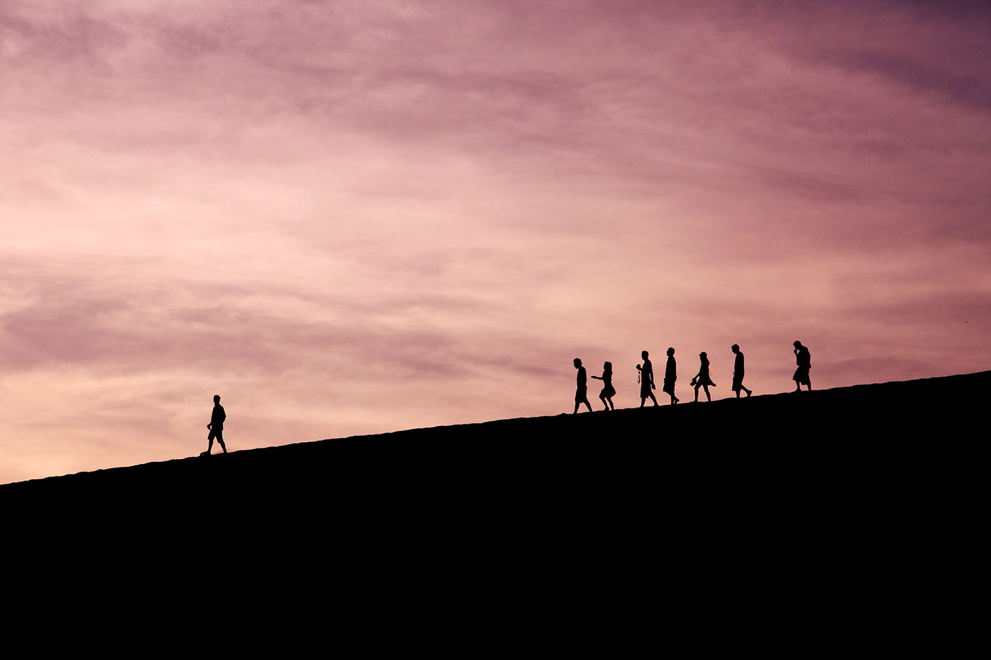 Person standing ahead of a group, leading them forward.