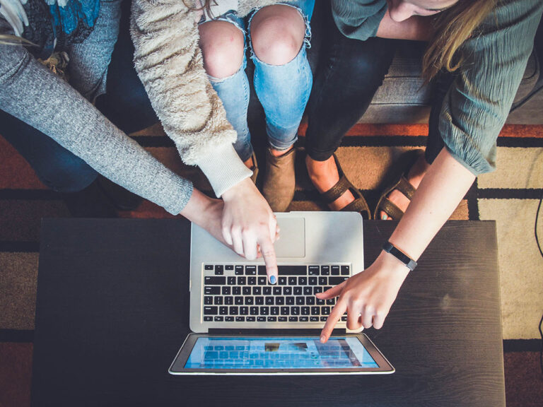 Three co-workers working together on the same screen. Feature photo by John Schnobrich on Unsplash.