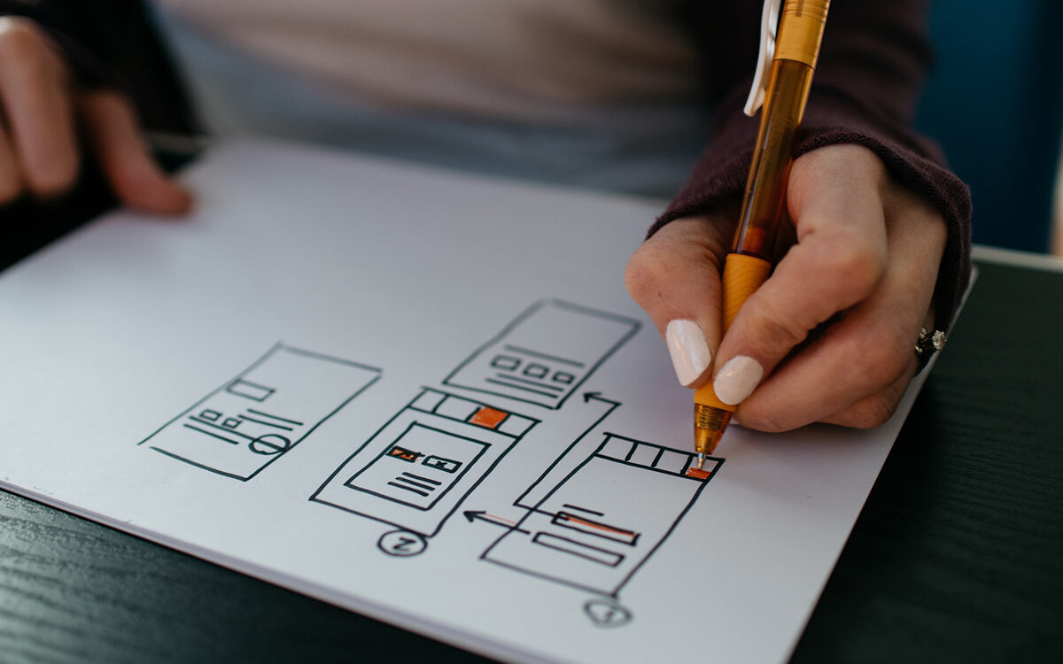 Kelly Sikkema – Unsplash Person drawing a diagram with a pen