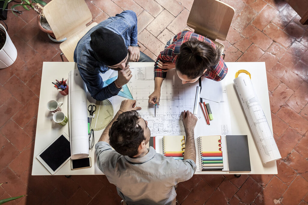 Teamwork. Three young architects working on a projec, ©loreanto / Adobe Stock