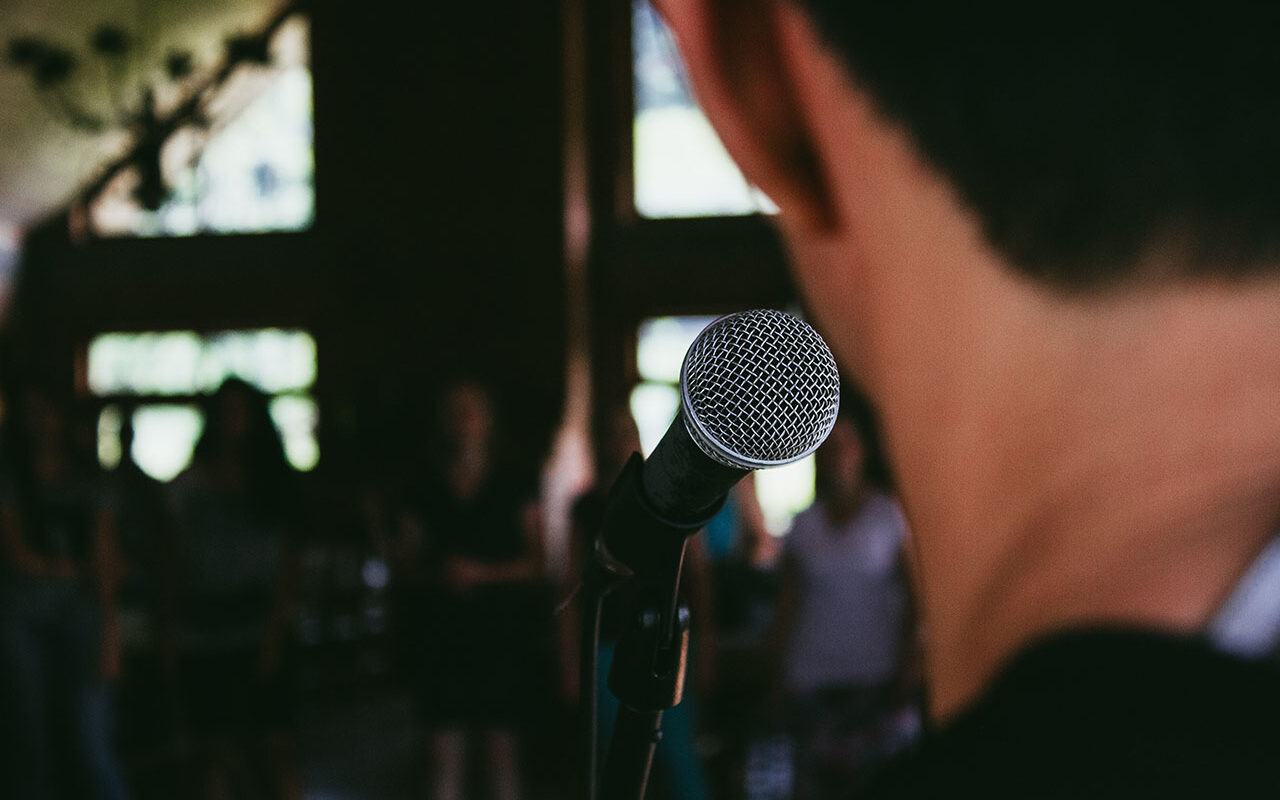 © Marcos Luiz Photograph / Unsplash Man standing in front of microphone, © Marcos Luiz Photograph / Unsplash