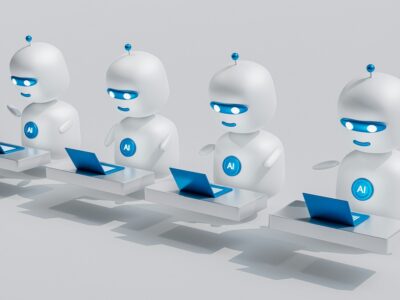 A line of 4 robots with AI written on their chest sit in front of computers