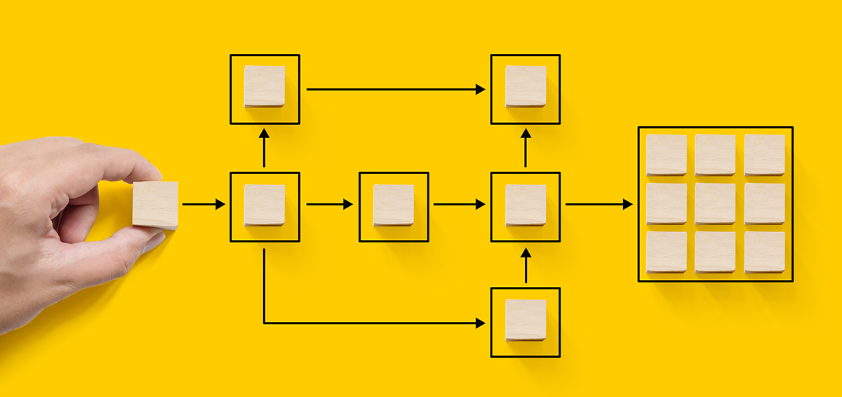 Hand holding wooden cube block arranging processing management on yellow background