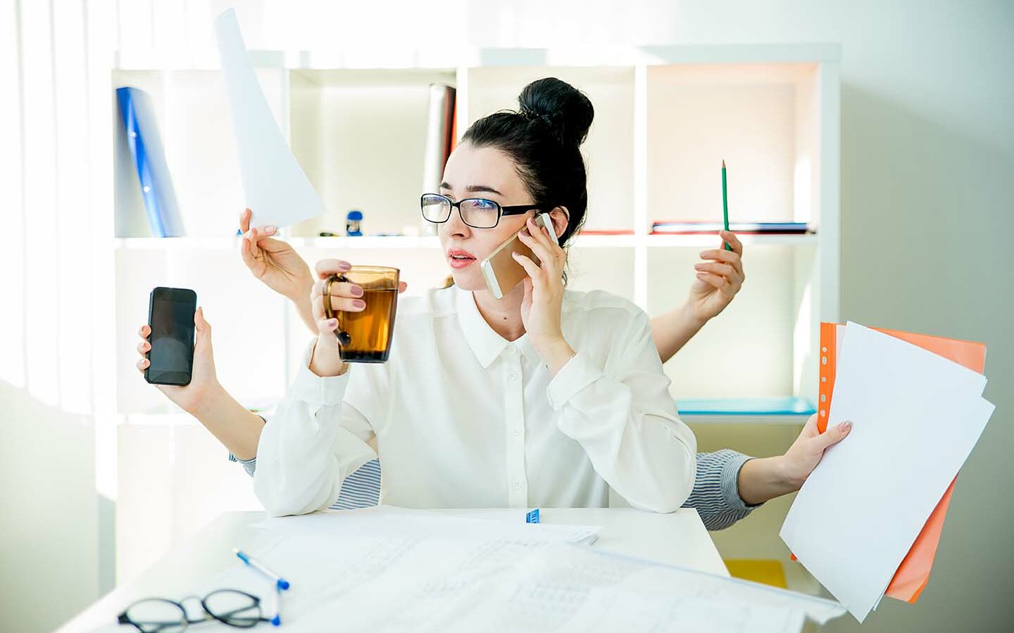 Elena Nichizhenova/AdobeStock A successful businesswoman is multitasking in office