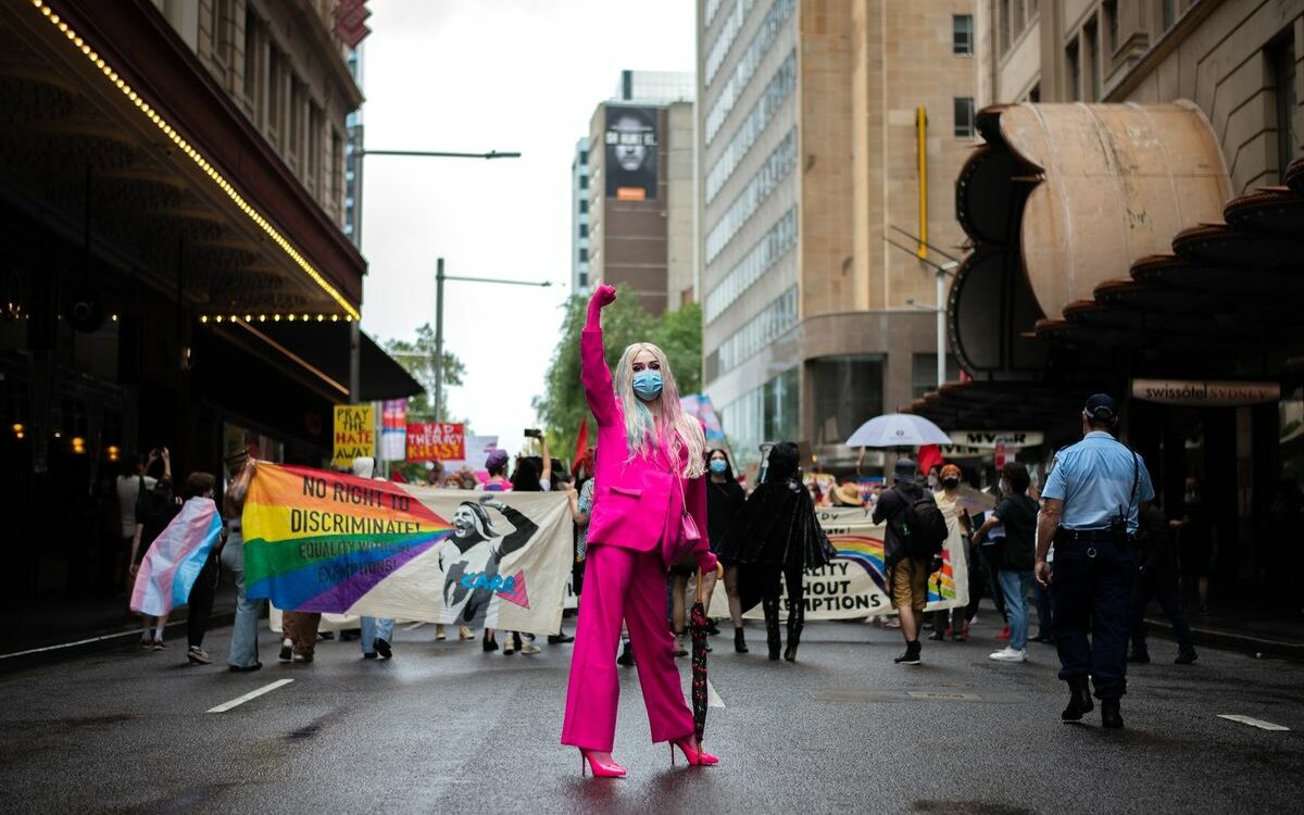 ©Nikolas Gannon/Unsplash A photo of an LGBT+ activist holding their fist up at a protest representing leadership as a member of the LGBT+ community