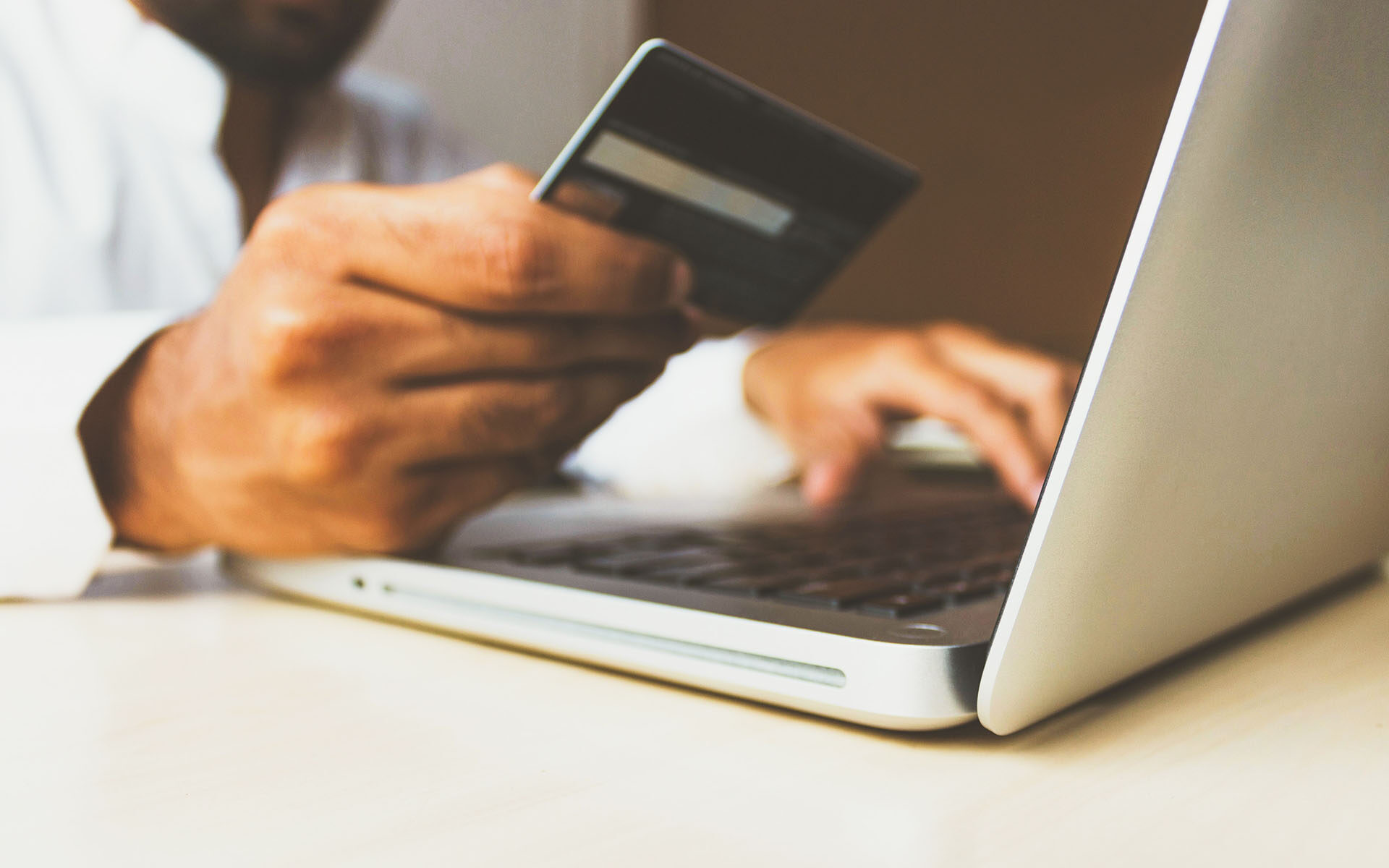 Photo-Credit-rupixen-unsplash Man buying something with a credit card online. Photo by rupixen.com on Unsplash.