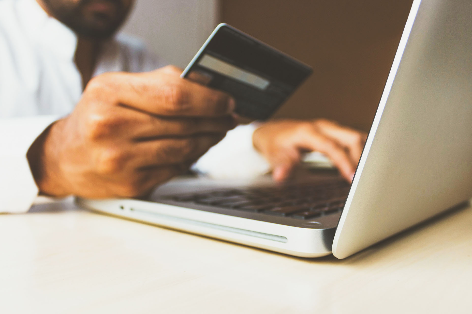 Man buying something with a credit card online. Photo by rupixen.com on Unsplash.