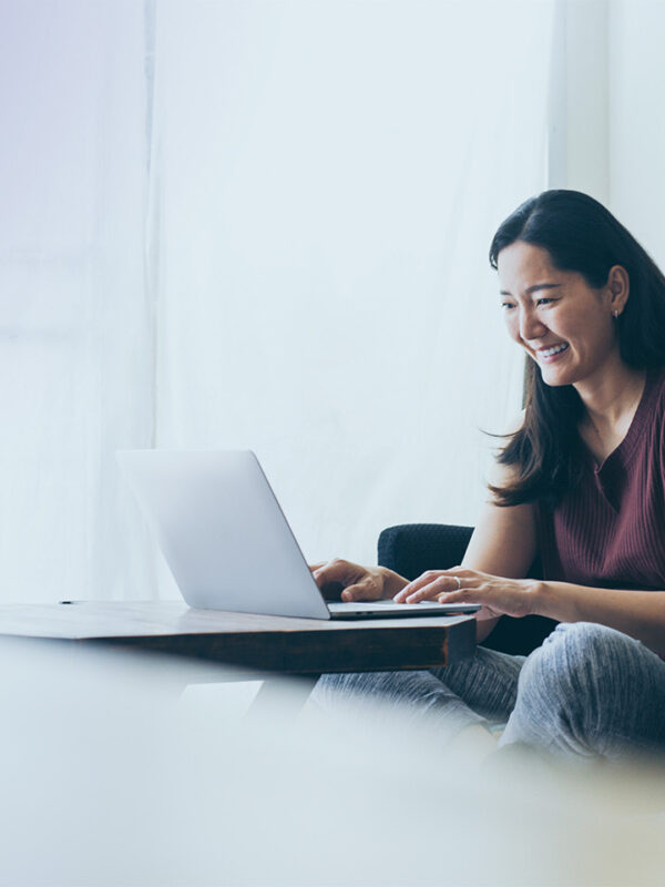 Using computer hand typing keyboard laptop online chatting search form internet while working sitting on sofa, Panitan/Adobe Stock