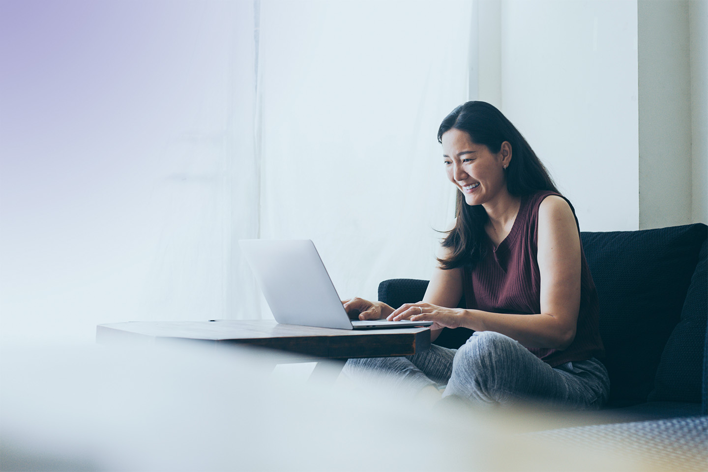 Using computer hand typing keyboard laptop online chatting search form internet while working sitting on sofa, Panitan/Adobe Stock