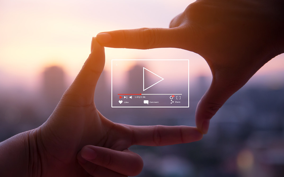Two hands framing a play button like on a Youtube video