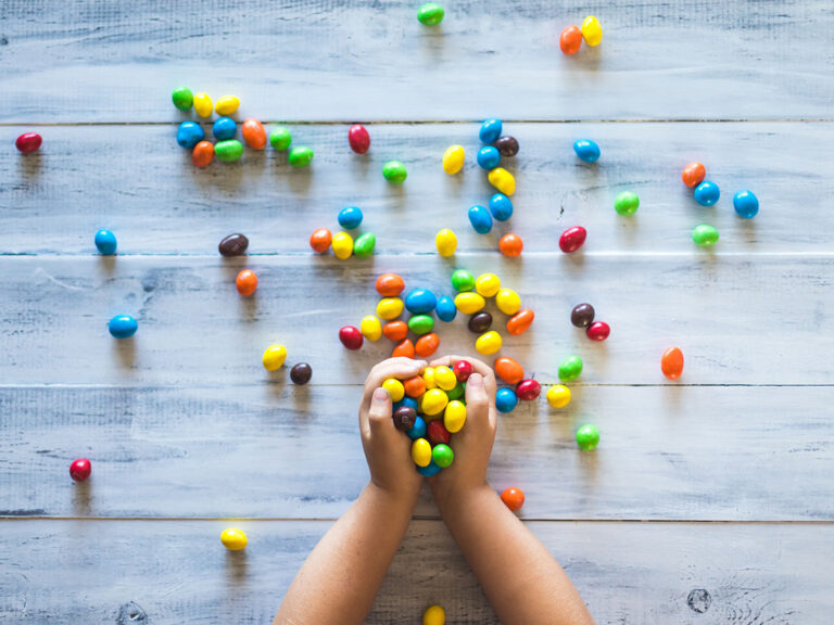 © Patrick Fore / Unsplash Selective photo of kid holding candies on gray wooden pallet board, © Patrick Fore / Unsplash