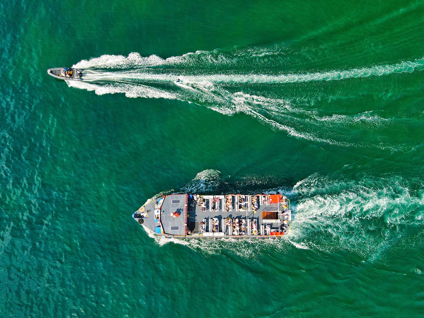 ©Red Zeppelin/Unsplash. Speedboat and passenger boat in the UK waters.